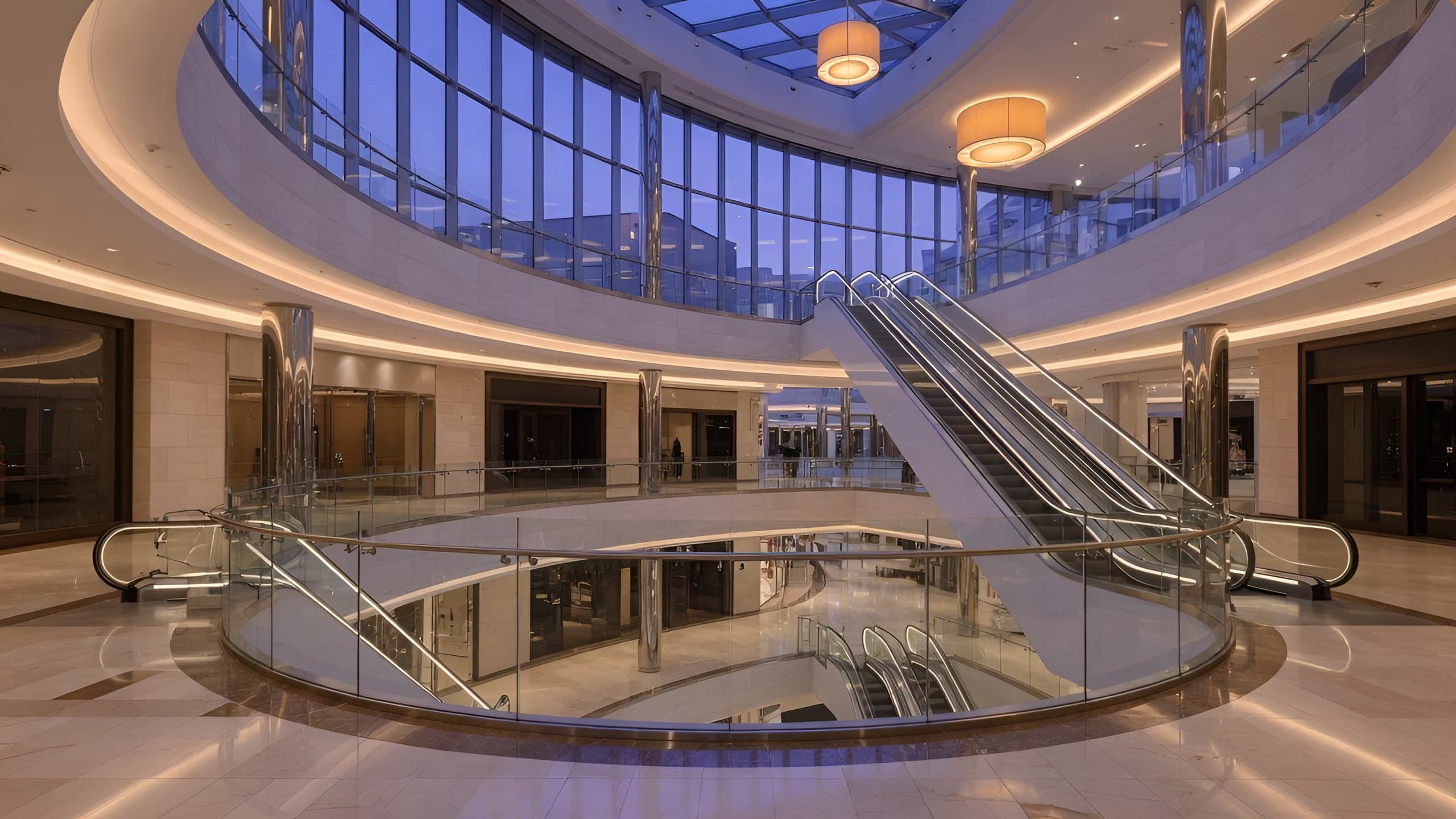 A bright shopping-mall atrium: balustrades, glass and ceiling carrying LED screens, all switched on