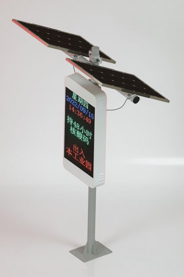 Pole-mounted solar LED display in a street scene